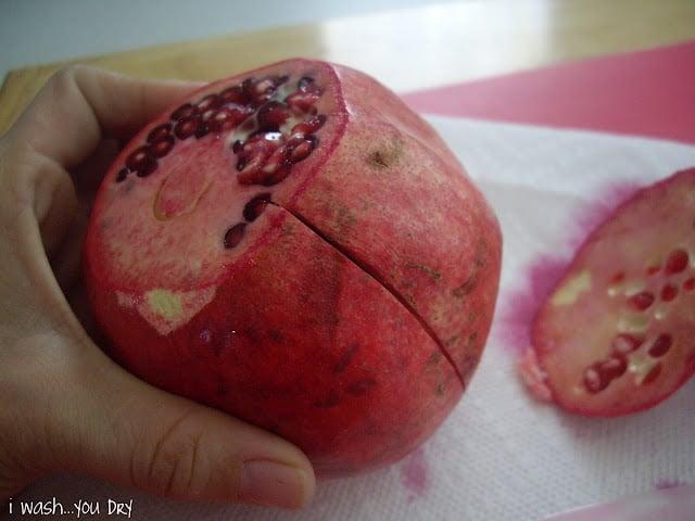 A close up of a pomegranate with the top and bottom removed. 