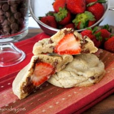 A close up look of a Strawberry stuffed Chocolate Chip Cinnamon Cookie split in half to showcase the stuffed strawberry