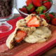 A close up look of a Strawberry stuffed Chocolate Chip Cinnamon Cookie split in half to showcase the stuffed strawberry