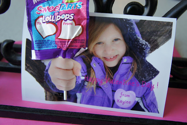 A close up of a Valentine\'s Day card; picture of little girl holding hand out with a lollipop attached to the picture.