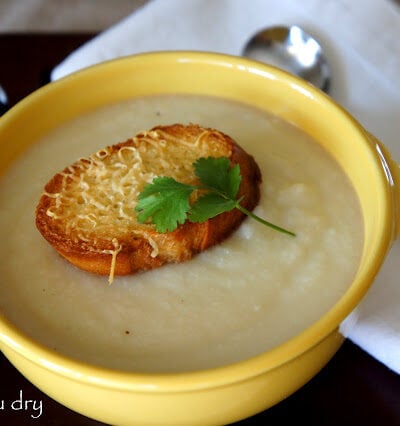 A bowl of Creamy Cauliflower Soup with a Asiago Crouton on top