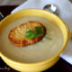 A bowl of Creamy Cauliflower Soup with a Asiago Crouton on top