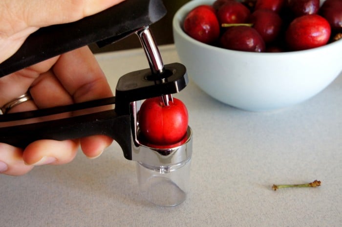 A close up of a cherry being pitted