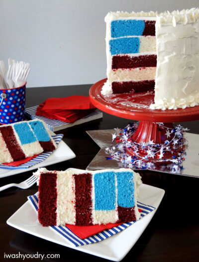 Slices of 5 layer 4th of July themed birthday cake on plates next to the full cake on a cake stand.