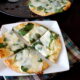 A sliced baked white pita pizza displayed on a plate