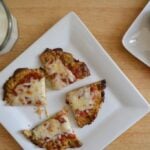 A plate with a sliced Cauliflower Crusted Pizza on it.