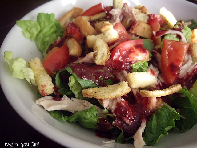 Salad topped with tomatoes and croutons in a bowl. 