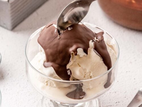 Bowl of vanilla ice cream with chocolate shell on top.