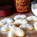 A close up of powdered Almond Crescent Cookies