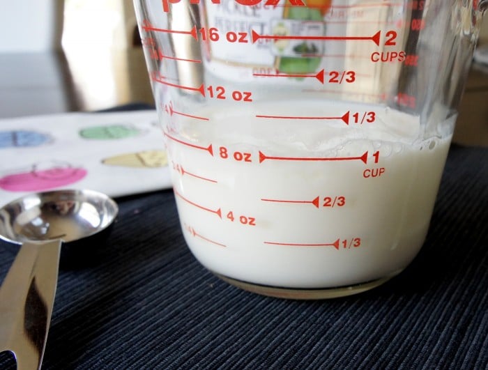A glass measuring cup with one cup of buttermilk