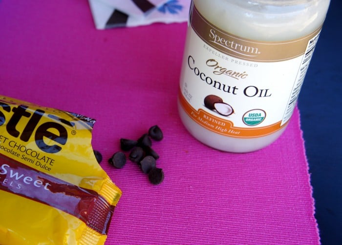 Chocolate chips next to a jar of coconut oil