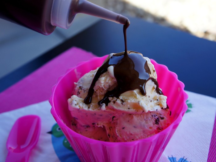 Scoops of ice cream in a bowl with 2 Ingredient Magic Shell being drizzled on it