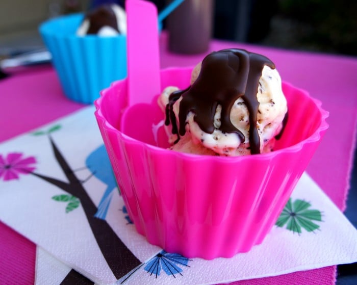 A cup of ice cream with hardened chocolate sauce on top
