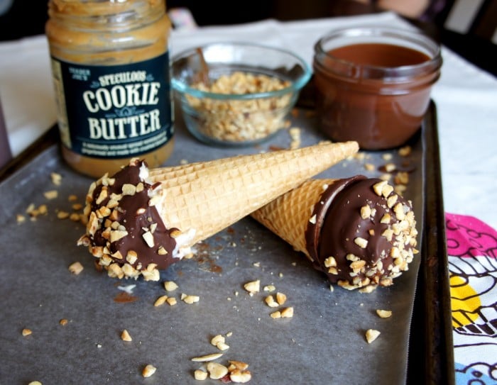 A pan with two chocolate dipped ice cream cones displayed on a pan