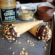 Two Homemade Cookie Butter Drumsticks displayed on a pan in front of the the ingredients needed to make it