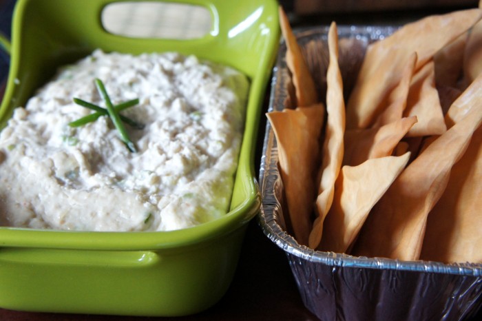 A container of dip and a container of chips next to it