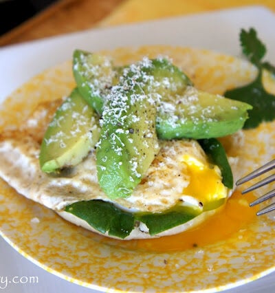 A plate with an Open Faced Egg and Avocado Sandwich on it
