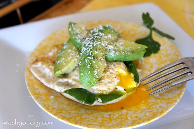 A plate with an Open Faced Egg and Avocado Sandwich on it