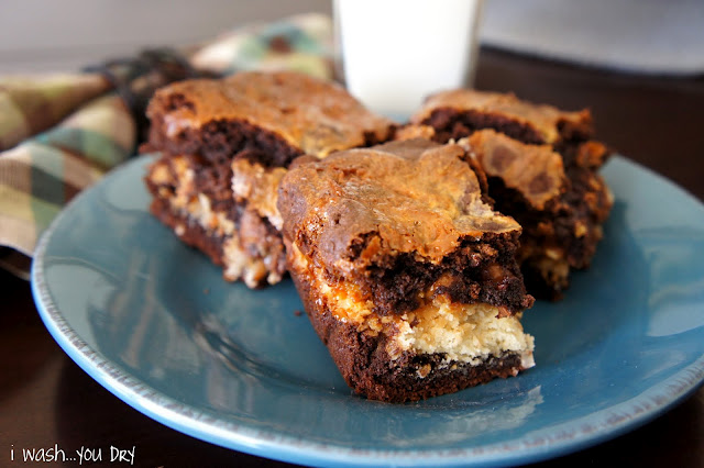 Three brownie squares on a plate next to a glass of milk