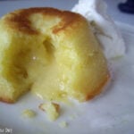 A close up of a a White chocolate Lemon Lava Cake broken open to expose the oozing center.