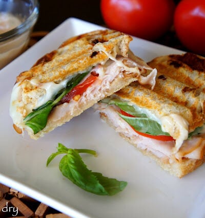 A Turkey Caprese Panini cut in half and displayed on a plate