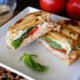 A Turkey Caprese Panini cut in half and displayed on a plate