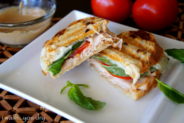 A Turkey Caprese Panini cut in half and displayed on a plate