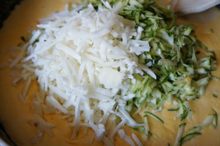 A pile of shredded potatoes and zucchini on a cutting board