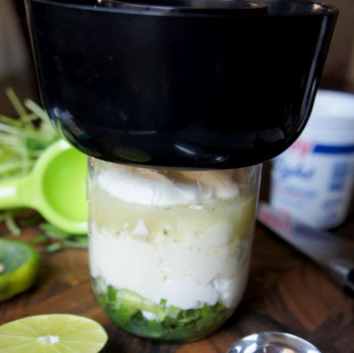 Salad dressing ingredients in a mason jar with a blender attachment on top