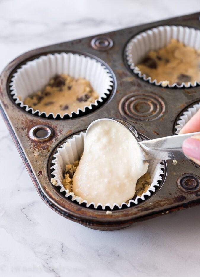 Start by mixing up a super simple chocolate chip cookie dough, then pressing a tablespoon's worth into a cupcake liner. Fill with a scoop of cheesecake batter!