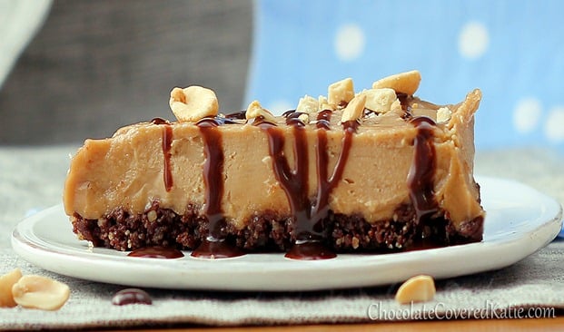 A slice of No-Bake Peanut Butter Pie on a plate with drizzled chocolate and nuts on top