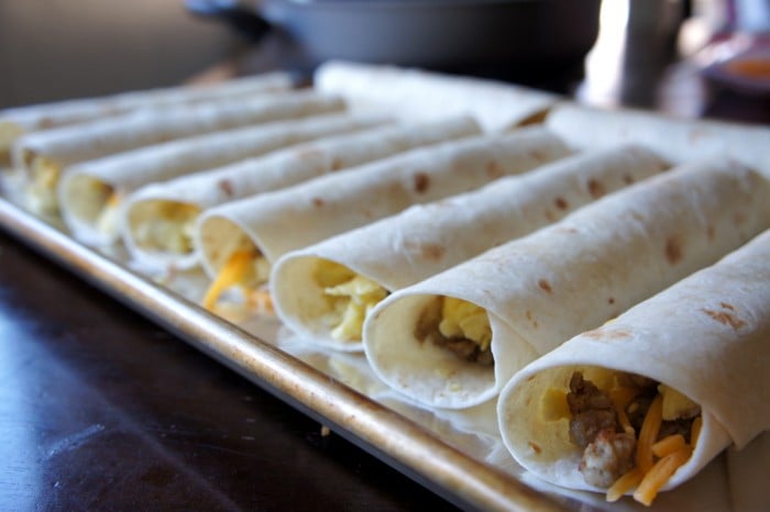 A pan filled with rolled breakfast sausage flautas