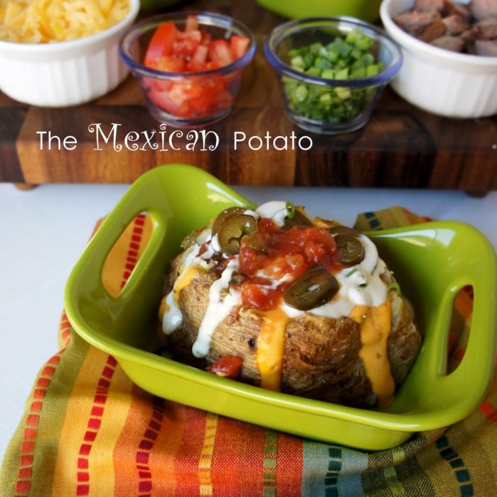 A baked potato on a green plate with a Mexican themed potato bar toppings