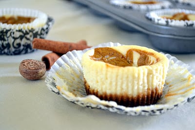 A close up of a pumpkin cheesecake with the muffin wrapper pulled down