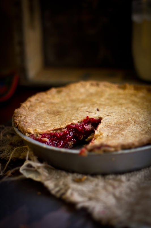 A raspberry pie with a slice removed from it showcasing an inside look