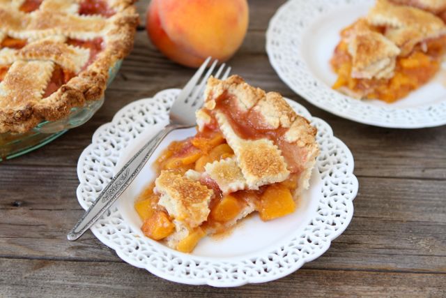 A slice of peach pie on a plate