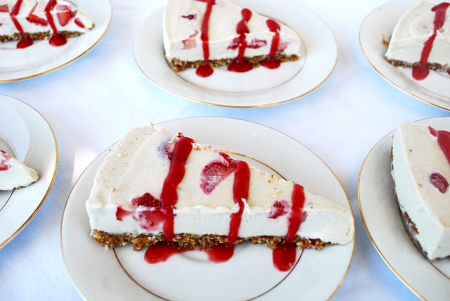 A slice of Strawberry Ice Cream Pie with drizzled strawberry sauce on top displayed on a plate