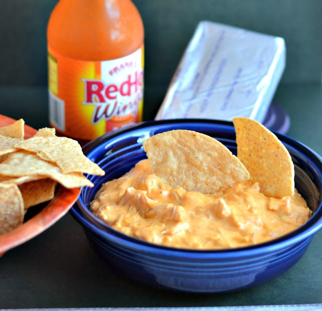 A chips dipped into a bowl of Buffalo Chicken Dip