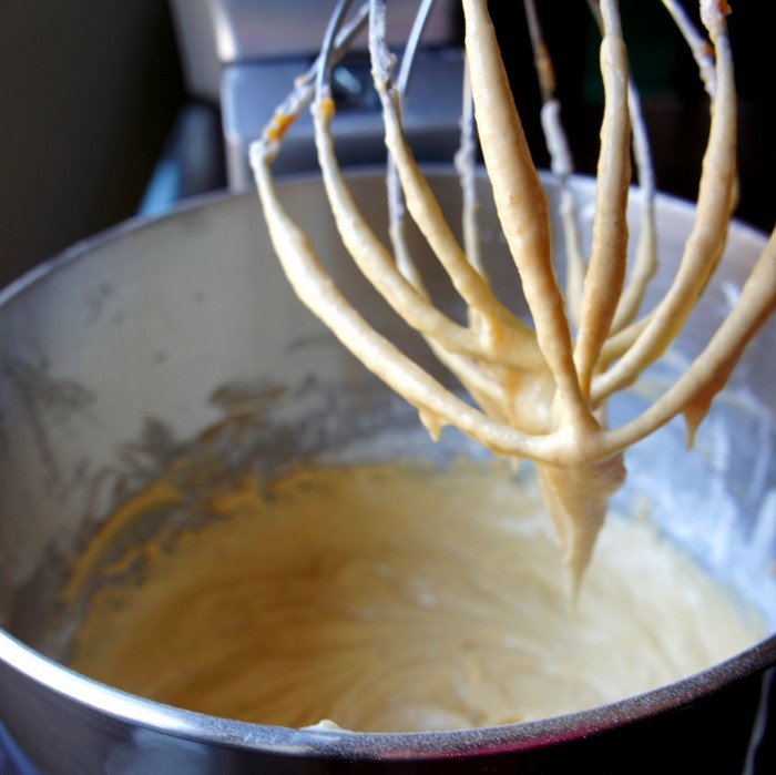 A close up of a beater over a mixing bowl to showcase the batter