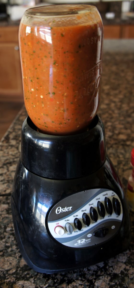 A close up of a mason jar full of salsa being blended