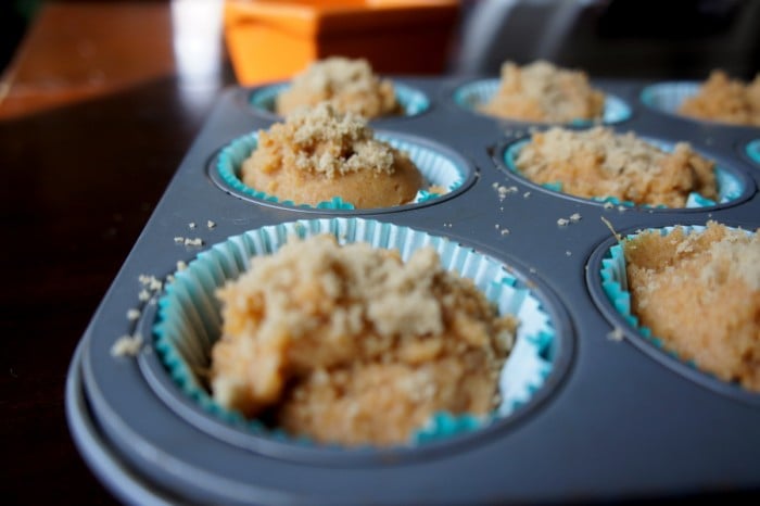 A close up of muffin batter in a muffin tin topped with a sugar topping