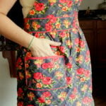 A close up of a woman with her hand in the pocket of a Jesse Steele Apron