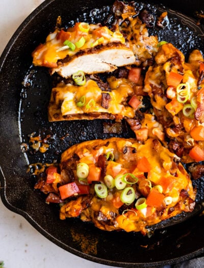 black skillet with cheese and bacon covered chicken breast.