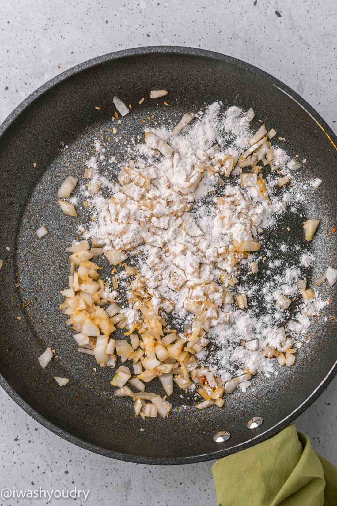 Onions and flour in black frying pan. 