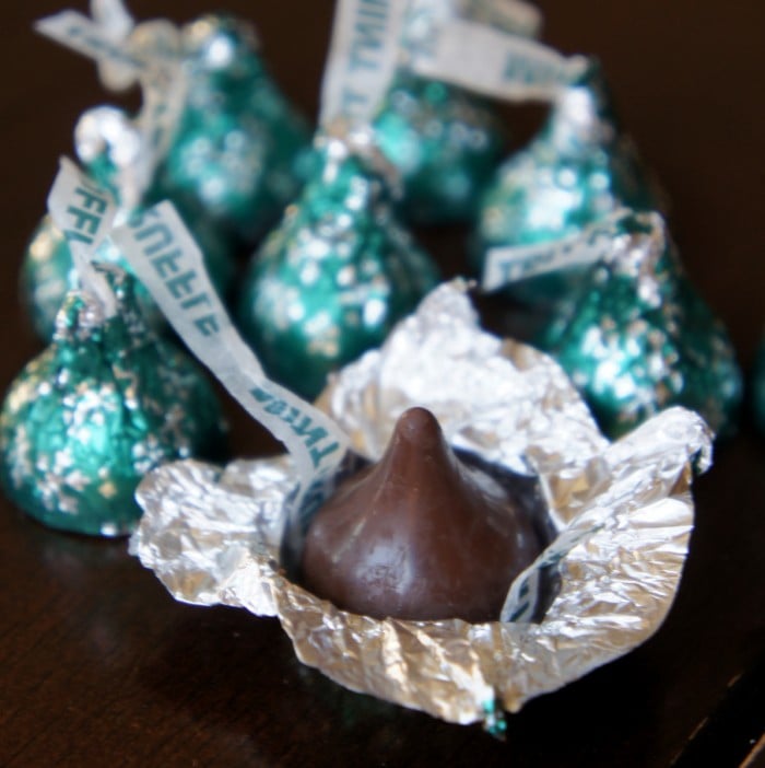 Mint Truffle Hershey Kisses surrounding one unwrapped Kiss