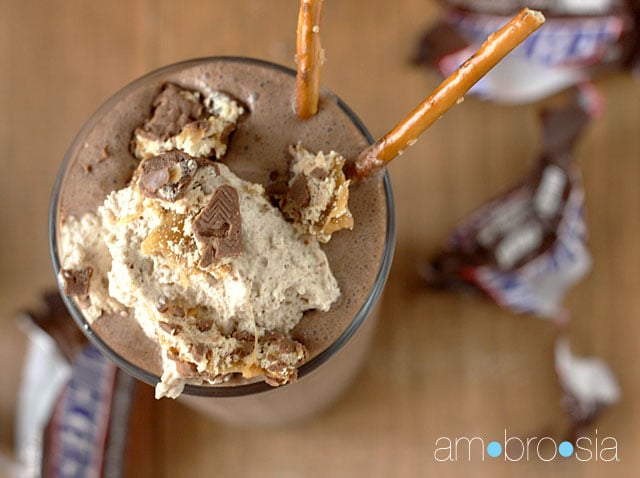 A look at the top of a Snickers Pretzel Milkshake with a scoop of ice-cream on top and chopped snickers pieces