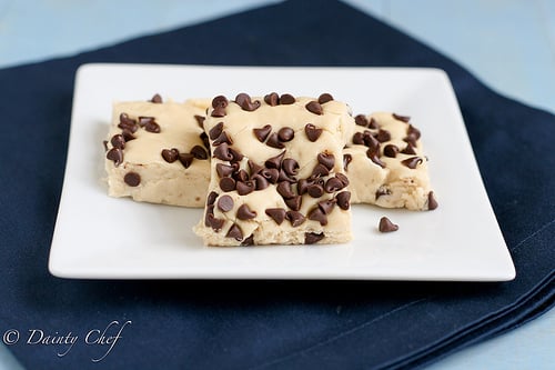Squares of white fudge with chocolate chips on a plate