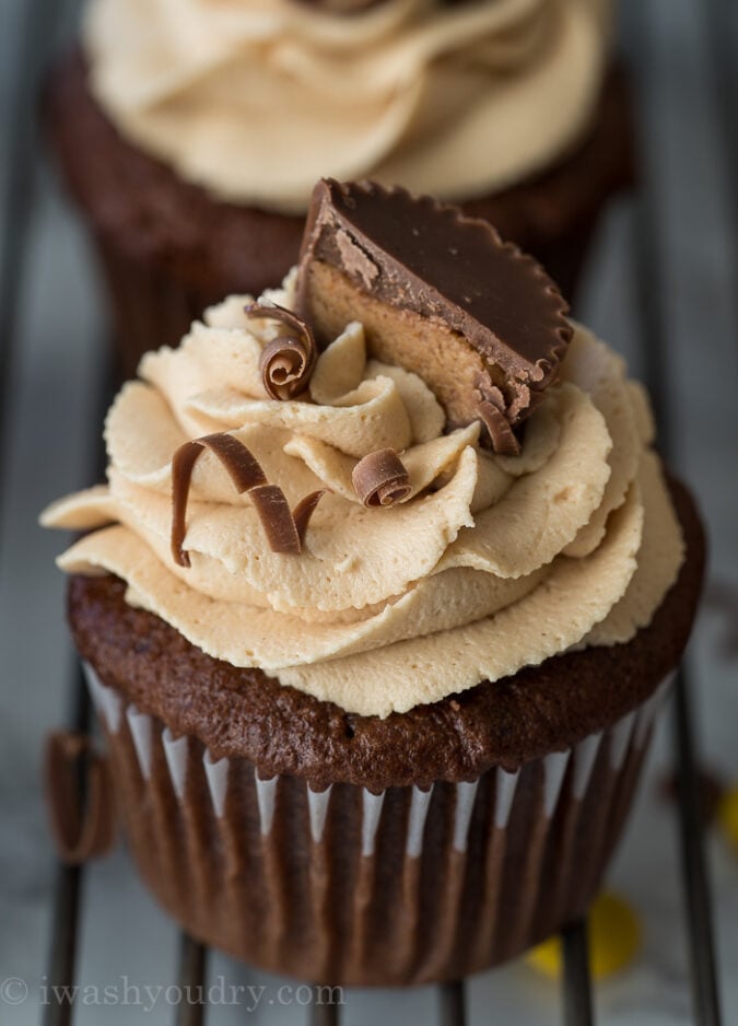 These Chocolate Peanut Butter Cupcakes with Peanut Butter Buttercream Frosting are filled with a surprise center that's sure to make you smile!