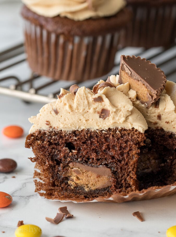 These Chocolate Peanut Butter Cupcakes with Peanut Butter Buttercream Frosting are filled with a surprise center that's sure to make you smile!