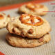 A close up of two cookies on top of each other with cinnamon chips and a pretzel on top